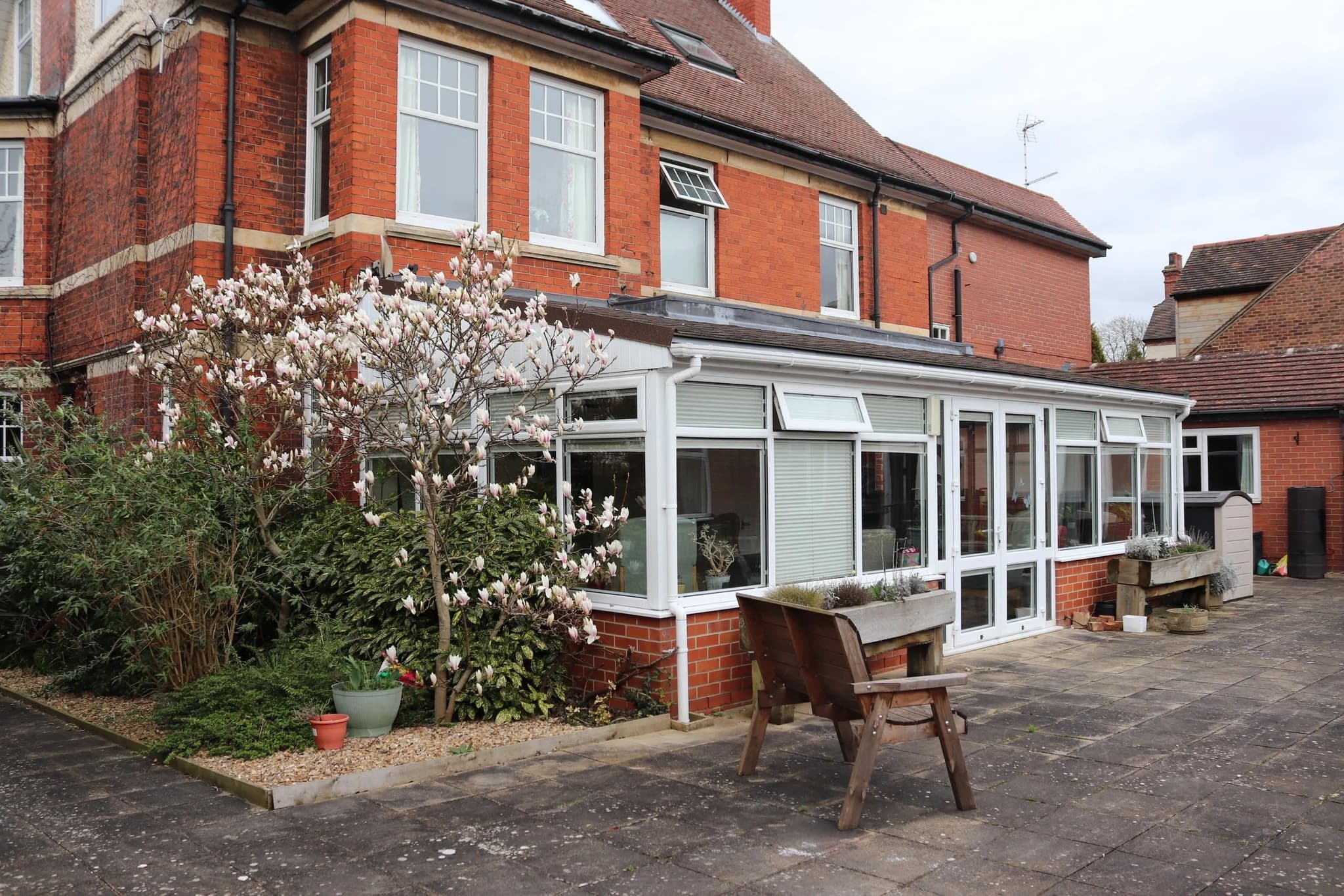 Bright sunlit conservatory and landscaped courtyard patio